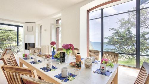 - une salle à manger avec une grande table fleurie dans l'établissement Villa Emeraude 5 bedrooms, à Saint-Cast-le-Guildo