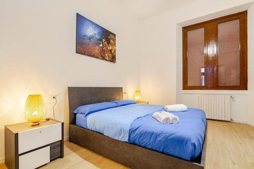 een slaapkamer met een groot bed met blauwe lakens bij Casa Marelli in Sesto San Giovanni