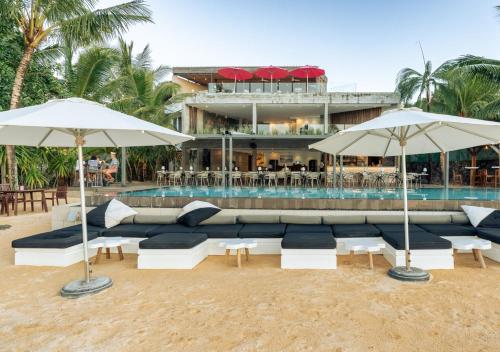 a pool with umbrellas and couches next to a resort at Mystik Life Style by NEWMARK in Mont Choisy