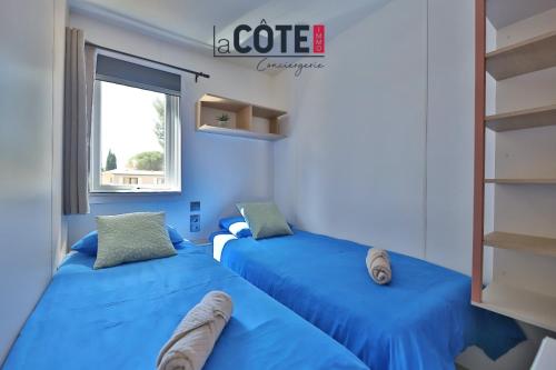 - 2 lits bleus dans une chambre avec fenêtre dans l'établissement Lou Soleil, à Carry-le-Rouet