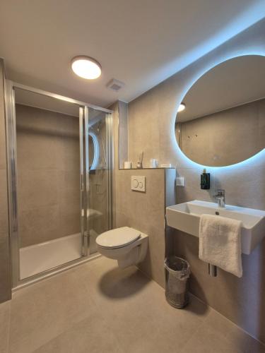 a bathroom with a toilet and a sink and a shower at Hotel Den Burg in Den Burg