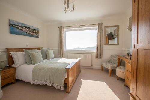 a bedroom with a large bed and a window at Mevagissey Bay Hotel in Mevagissey