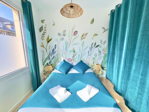 - une petite chambre avec un lit bleu et des oreillers bleus dans l'établissement T2 Cosy Centre Ville Amiens - Rez-de-chaussée, à Amiens