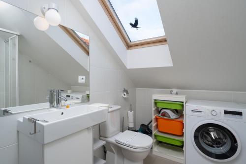 a bathroom with a sink and a washing machine at Veleslavin Apartments in Prague