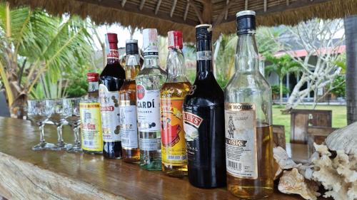a group of bottles of alcohol sitting on a table at Silver Fern Beach Retreat in Sekotong