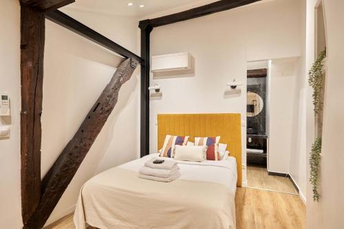 une chambre avec un lit avec une tête de lit en bois dans l'établissement Apartment Le Marais by Studio prestige, à Paris