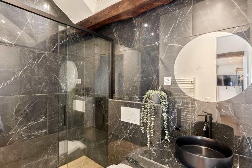 une salle de bain avec un lavabo et un miroir dans l'établissement Apartment Le Marais by Studio prestige, à Paris