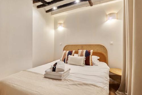 une chambre avec un lit avec deux serviettes dessus dans l'établissement Apartment Le Marais by Studio prestige, à Paris