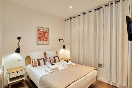 - une chambre avec 2 lits et une télévision dans l'établissement Apartment 2 bedrooms Center of Paris, à Paris