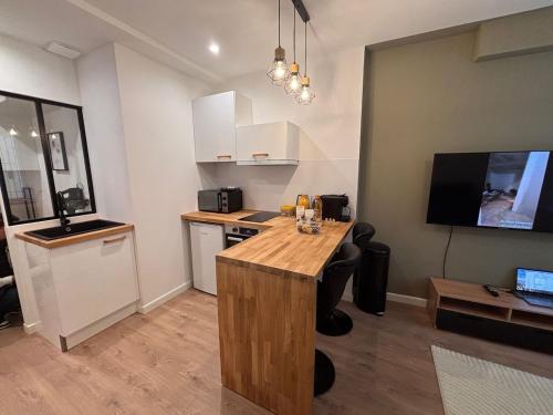 une cuisine avec un comptoir en bois dans une pièce dans l'établissement Charmant appartement aixois, à Aix-en-Provence