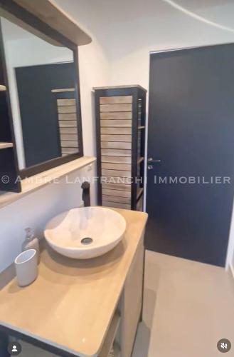 La salle de bains est pourvue d'un lavabo blanc sur un comptoir. dans l'établissement Maison en pierre - 6 personnes - piscine, à Porto-Vecchio