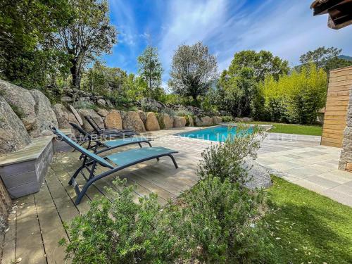 un patio avec des chaises et une piscine dans l'établissement Maison en pierre - 6 personnes - piscine, à Porto-Vecchio