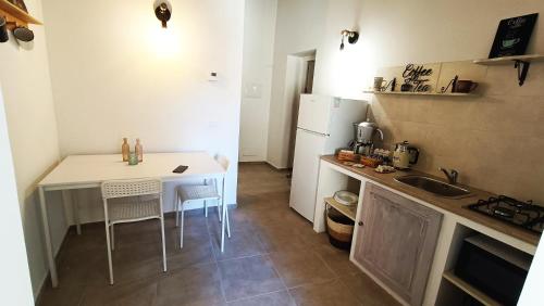 a small kitchen with a table and a refrigerator at Coffee&Tea House Casetta Tipica a 5min dal centro storico in LʼAquila