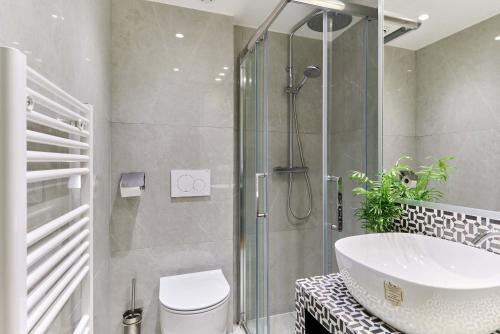 une salle de bain avec une douche, des toilettes et un lavabo dans l'établissement Apartment Center of Paris by Studio prestige, à Paris