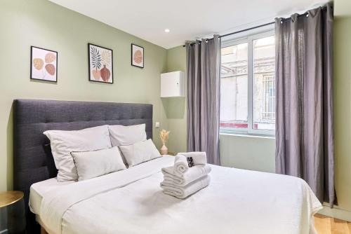 une chambre avec un grand lit blanc avec une fenêtre dans l'établissement Apartment Center of Paris by Studio prestige, à Paris