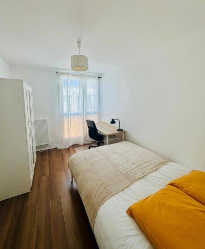 une chambre avec un grand lit et un bureau dans l'établissement Apartement 8 personnes, 4 lits Créteil, metro 20 min de Paris, à Créteil
