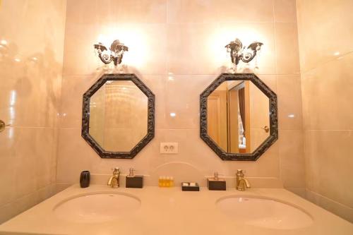 two sinks in a bathroom with two mirrors at Captain Studio in Kotor