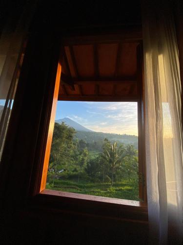 a window with a view of a mountain view at The Alam Bungalow & Restaurant in Tetebatu