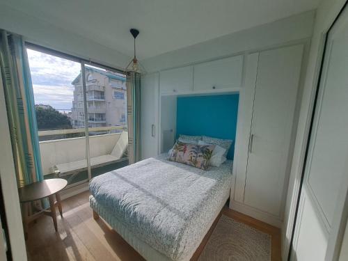 une chambre avec un lit et une grande fenêtre dans l'établissement T2 centre, plage à 2 minutes, parking, à Arcachon