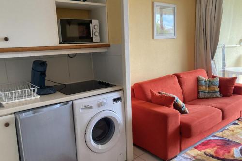- un salon avec un canapé rouge et un lave-linge dans l'établissement Pretty studio with garden close to the sea, à Cannes