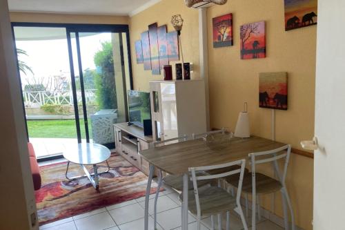 une cuisine avec une table, des chaises et un réfrigérateur dans l'établissement Pretty studio with garden close to the sea, à Cannes