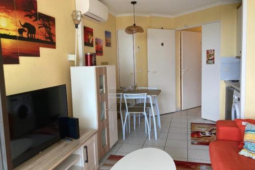 - un salon avec un réfrigérateur et une table dans l'établissement Pretty studio with garden close to the sea, à Cannes