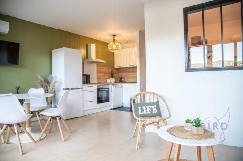 - une cuisine avec des appareils blancs, une table et des chaises dans l'établissement Charming apartment ideally located in Mandelieu-la-Napoule, à Mandelieu-la-Napoule