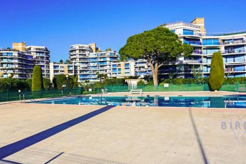 une piscine devant certains immeubles d'habitation dans l'établissement Charming apartment ideally located in Mandelieu-la-Napoule, à Mandelieu-la-Napoule