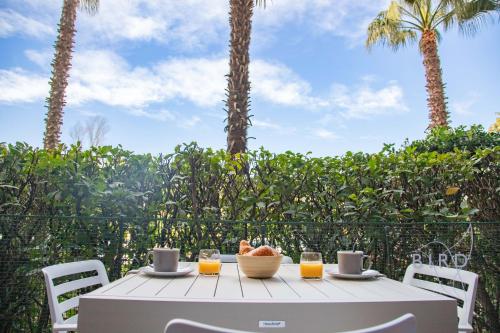 - une table avec un bol de fruits et deux verres de jus d'orange dans l'établissement Charming apartment ideally located in Mandelieu-la-Napoule, à Mandelieu-la-Napoule