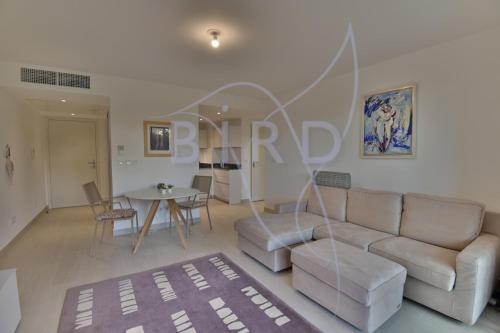 un salon avec un canapé et une table dans l'établissement Waterfront apartment with private garden, à Villeneuve-Loubet