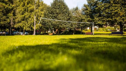 two benches in a field with a soccer goal at POŁONINY Resort in Bukowiec