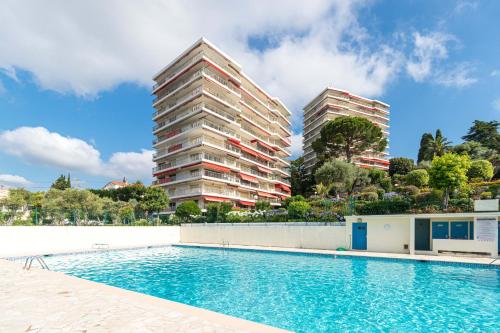 2 grands bâtiments à côté d'une piscine dans l'établissement Sea View & Gardens in Antibes, à Antibes