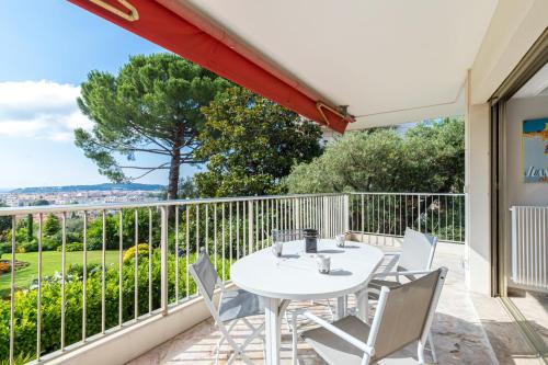 un patio avec une table et des chaises blanches sur un balcon dans l'établissement Sea View & Gardens in Antibes, à Antibes