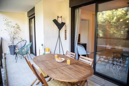une salle à manger avec une table et des chaises en bois dans l'établissement Superb apartment with pool tennis & parking, à Cannes