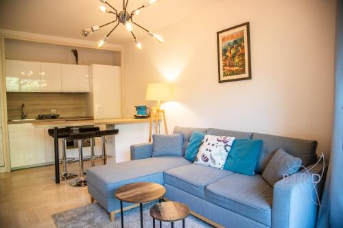 un salon avec un canapé bleu et une cuisine dans l'établissement Superb apartment with pool tennis & parking, à Cannes