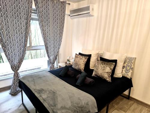 une chambre avec un lit avec des oreillers et une fenêtre dans l'établissement Escapade cosy avec piscine au centre-ville - IDEAL POUR COUPLES ET PROFESSIONNELS, à Cannes