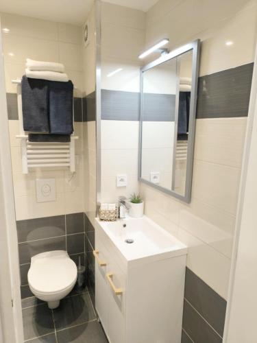 une salle de bain blanche avec des toilettes et un lavabo dans l'établissement Escapade cosy avec piscine au centre-ville - IDEAL POUR COUPLES ET PROFESSIONNELS, à Cannes