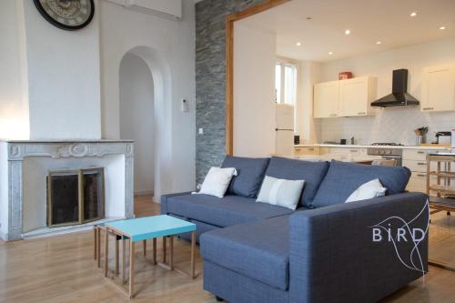 un salon avec un canapé bleu et une cheminée dans l'établissement Beautiful apartment Place Nationale in Antibes old town, à Antibes