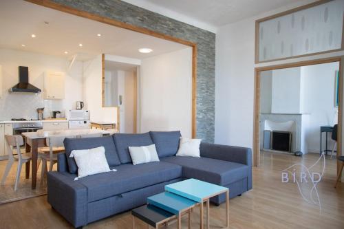un salon avec un canapé bleu et une cuisine dans l'établissement Beautiful apartment Place Nationale in Antibes old town, à Antibes