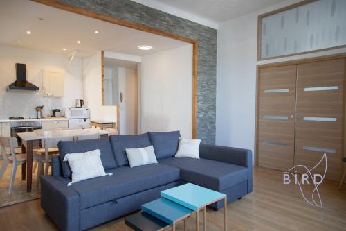 un salon avec un canapé bleu et une cuisine dans l'établissement Beautiful apartment Place Nationale in Antibes old town, à Antibes