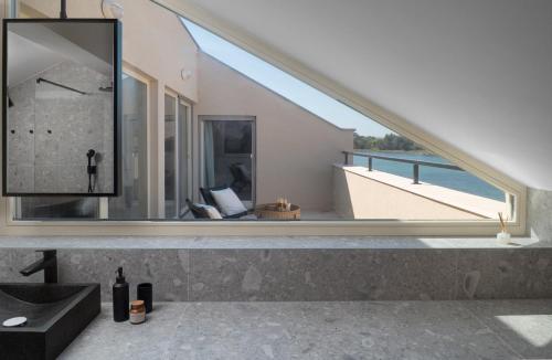 ein Badezimmer mit Waschbecken und großem Spiegel in der Unterkunft Luxury Villa Lovre seaside heated pool sauna in Nin