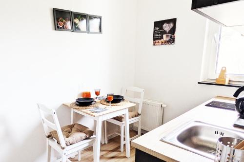 a kitchen with a small white table and chairs at Wohnung in Siegen in Wilnsdorf