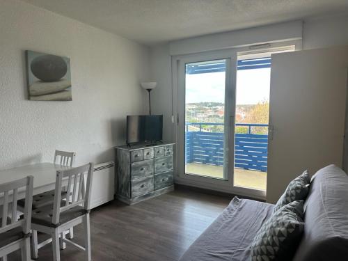 un salon avec un canapé, une table et une télévision dans l'établissement T2 Bord de plage, résidence Bleu Marine 46, à Lacanau-Océan