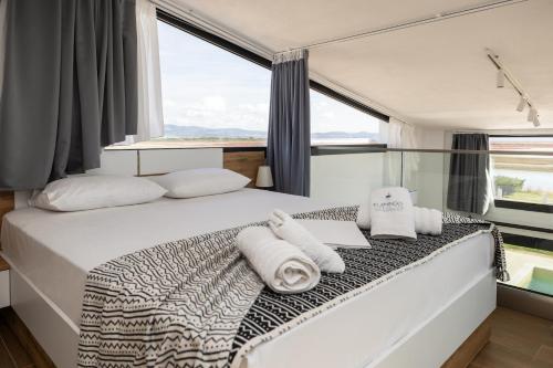 ネア・ポティダイアにあるFlamingo View Suites & Villasのタオルが敷かれたベッドのある寝室