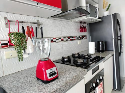a red blender sitting on top of a kitchen counter at En el centro Con cochera in Trujillo