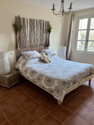 - un ours en peluche assis sur un lit dans une chambre dans l'établissement Maison Provencale avec piscine, à Saint-Maximin-la-Sainte-Baume
