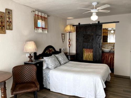 a bedroom with a bed and a chair and a table at La Casita Azul, L'Escala, Con climatización in L'Escala