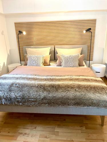 a bedroom with a large bed with a large headboard at Das AMBIENTE I - Komfortables Wohnerlebnis mit Moselromantik - Herzlich Willkommen - in Zell an der Mosel