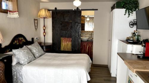 a small bedroom with a bed and a kitchen at La Casita Azul, L'Escala, Con climatización in L'Escala