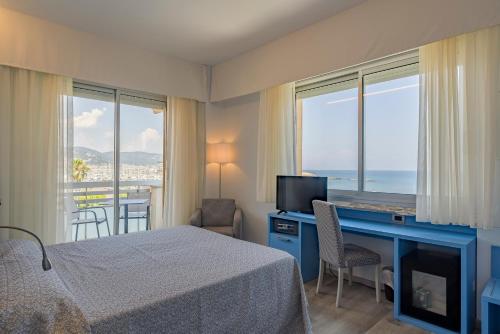 a hotel room with a bed and a desk with a television at Hotel Garden Lido in Loano